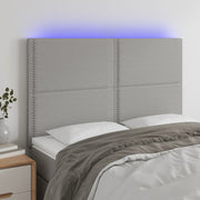 sengegavl med LED-lys 144x5x118/128 cm stof lysegrå