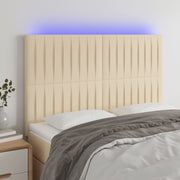 sengegavl med LED-lys 144x5x118/128 cm stof cremefarvet