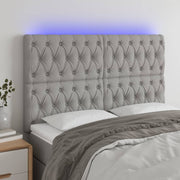 sengegavl med LED-lys 144x7x118/128 cm stof lysegrå