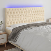 sengegavl med LED-lys 180x7x118/128 cm stof cremefarvet