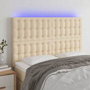 sengegavl med LED-lys 144x5x118/128 cm stof cremefarvet