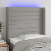 sengegavl med LED-lys 83x16x118/128 cm stof lysegrå