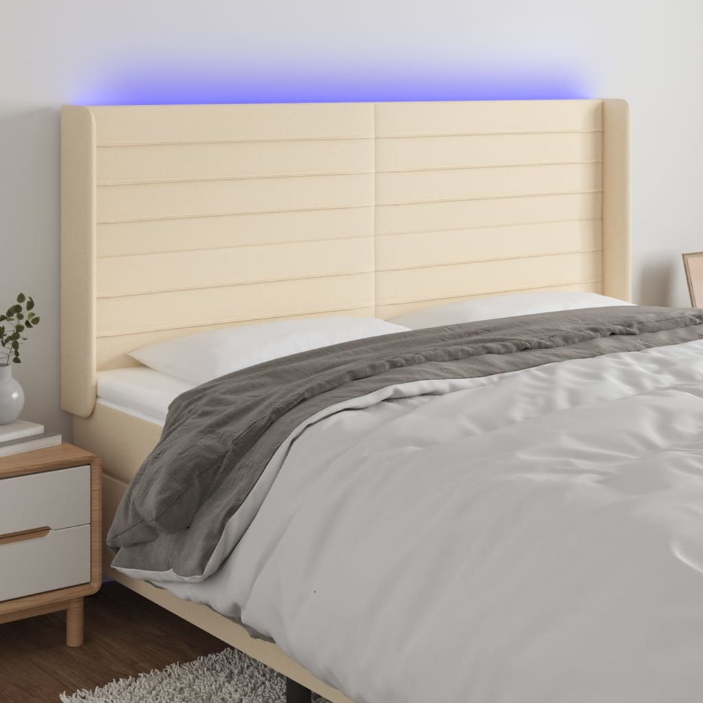 sengegavl med LED-lys 163x16x118/128 cm stof cremefarvet