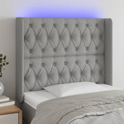 sengegavl med LED-lys 103x16x118/128 cm stof lysegrå